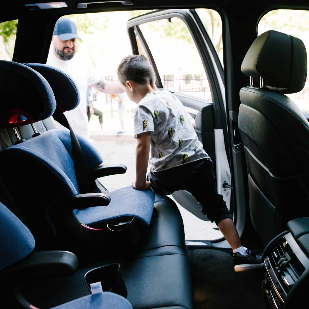 boy getting out of his clek Oobr booster car seat