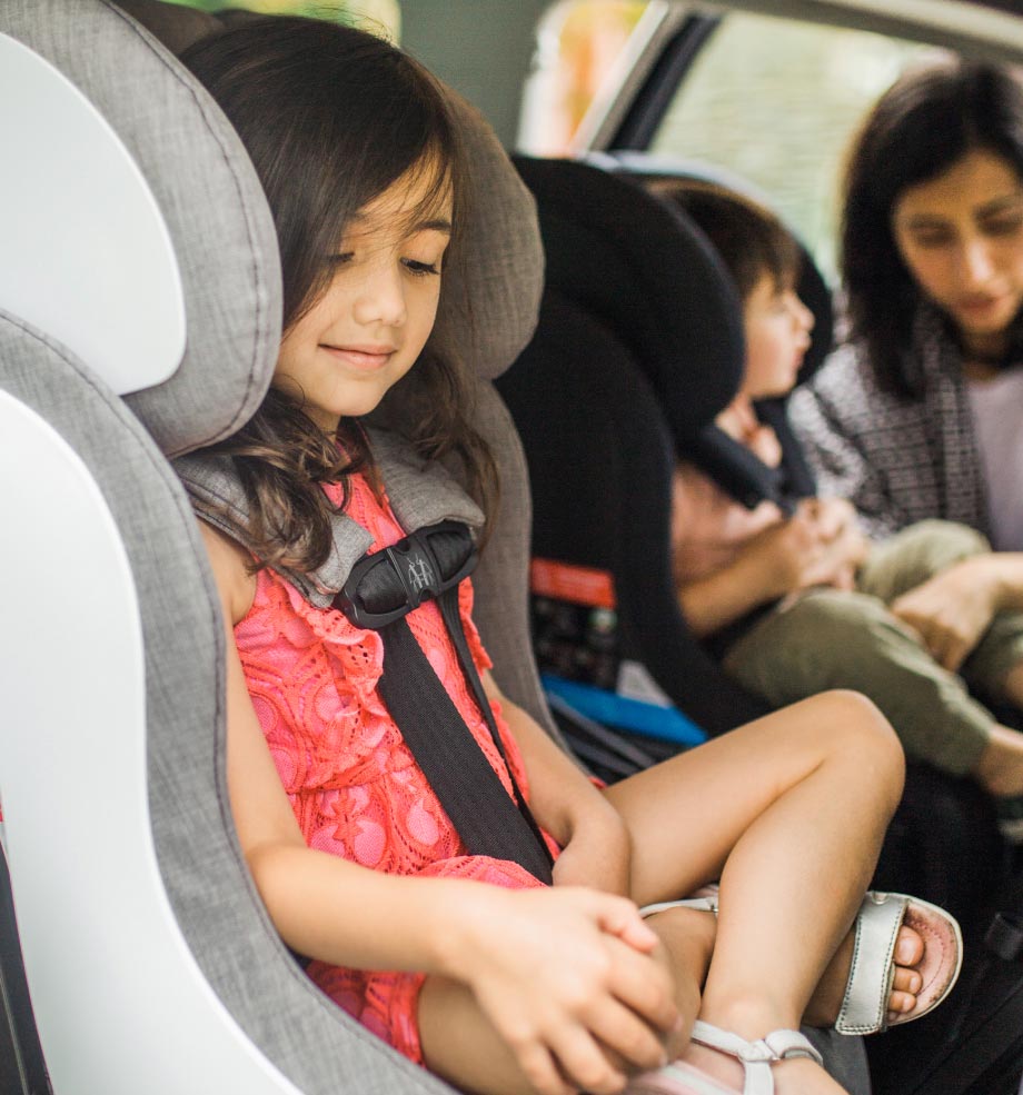 mother buckling her son and daughter into their Clek convertible car seats