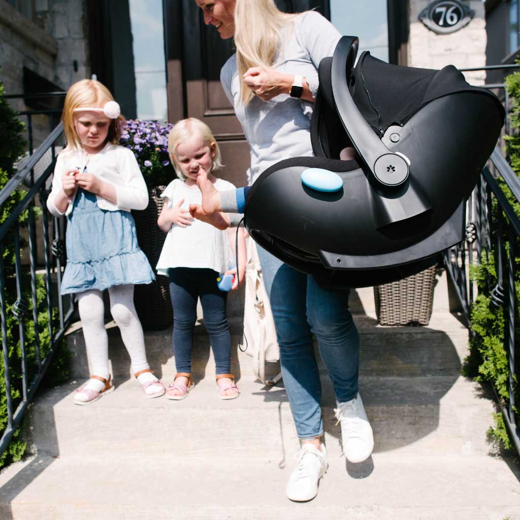 Mom carrying her newborn in a Clek infant car seat