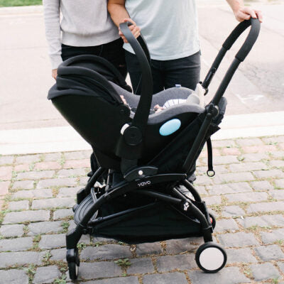 Mother and father pushing the Clek Liing infant car seat on a BABYZEN YOYO Stroller